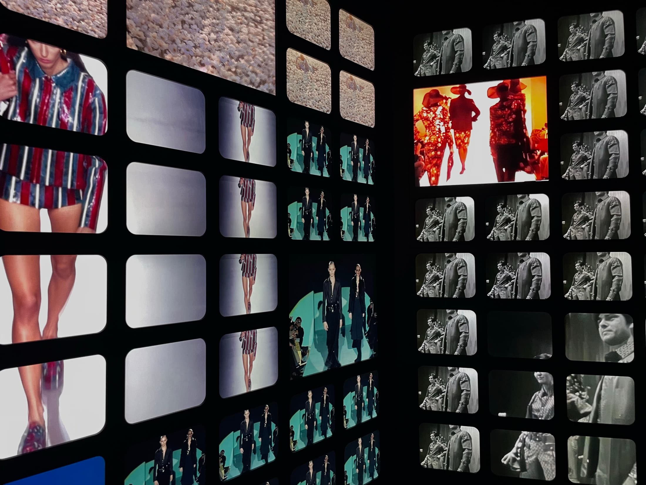 A wall of backlit film frames running fashion footage