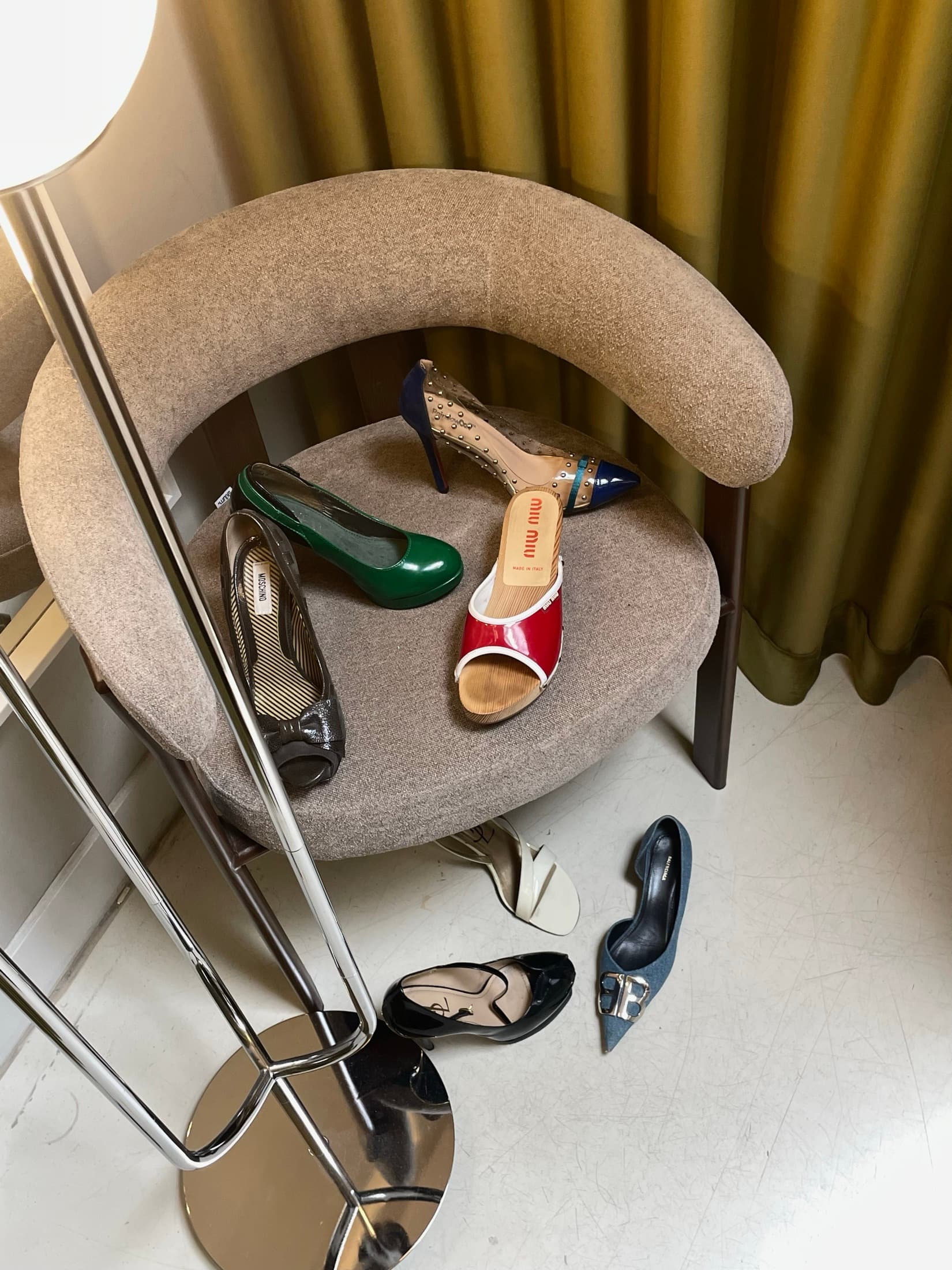 Heels arranged along a curved cream shelf